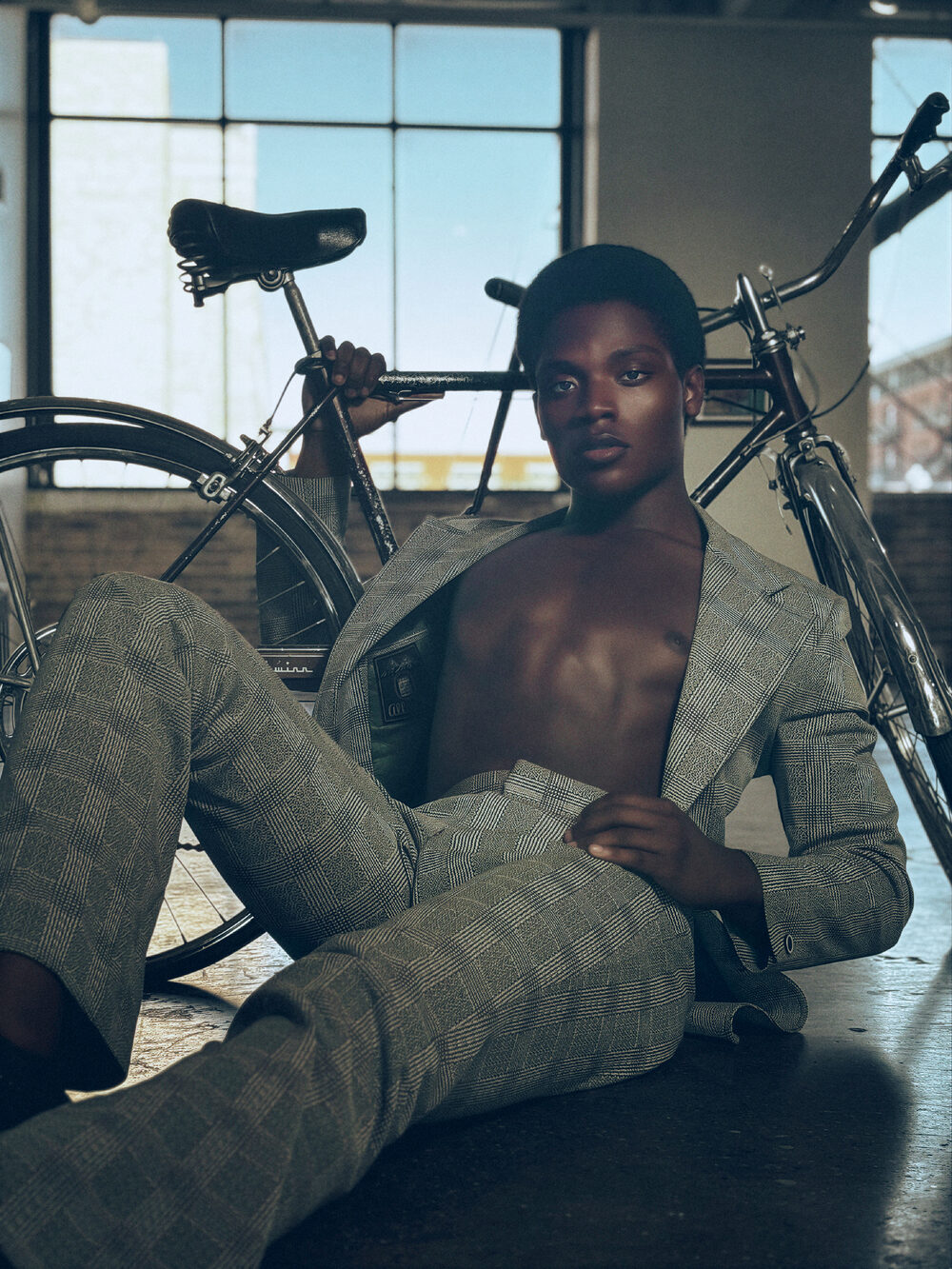 Fashion portrait in a plaid suit beside a bicycle
